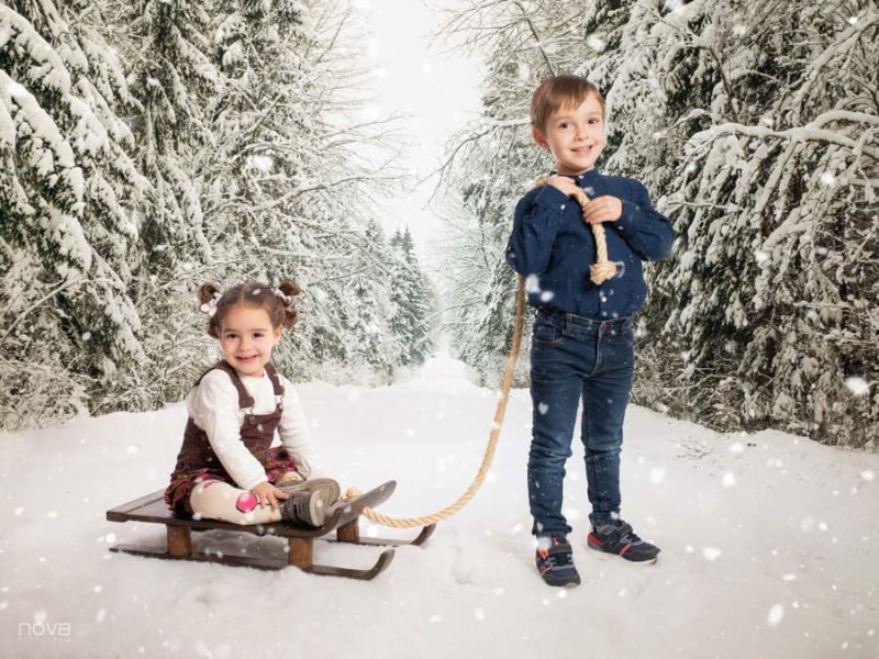 Niños en la nieve con trineo